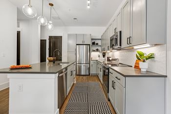 A modern kitchen with stainless steel appliances and white cabinets.